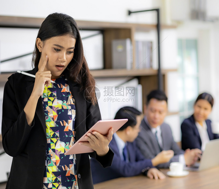 以智能平板工作思考站在桌前的咖啡厅会议室与背景商业团队一起使用混合背景工作图片