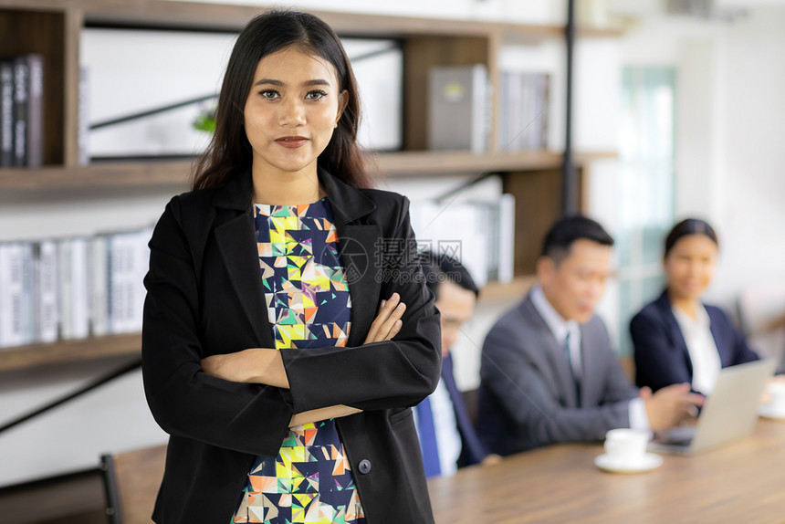 商业女人站在咖啡馆会议室桌前与背景商业团队在上使用混合工作图片