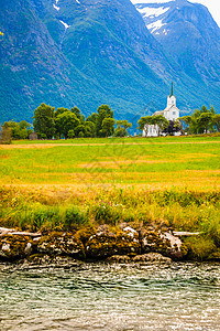 约斯特德尔斯布林挪威SognogFjordane县Stryn市的山区景观和白木奥普斯特伦教堂背景