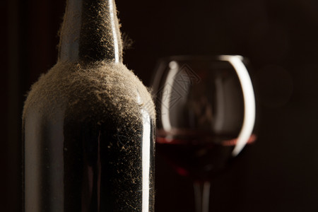 达斯帝古老的葡萄酒瓶和杯深底有红葡萄酒图片