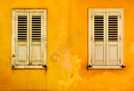 希腊雅典Plaka区两扇有百叶窗的黄墙图片