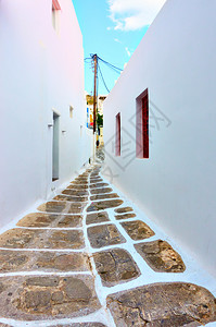 希腊Mykonos传统白人房屋间小街道的视角图片