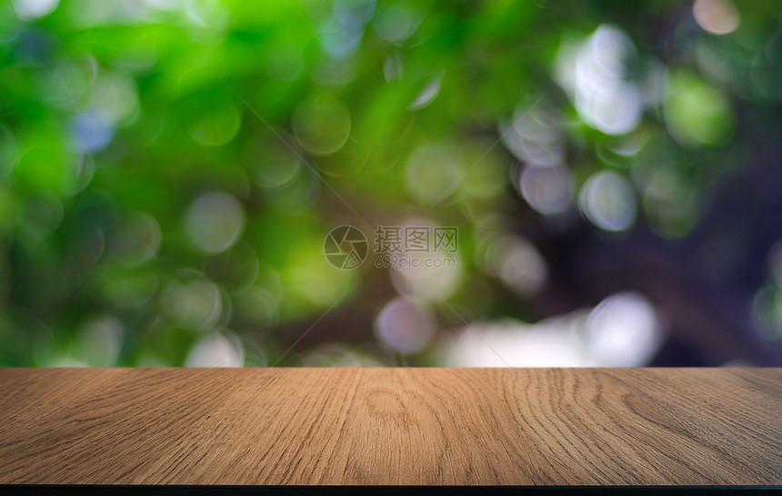 在餐厅的抽象模糊布基背景面前的空暗黑木桌可以用于显示或蒙合您的产品图片