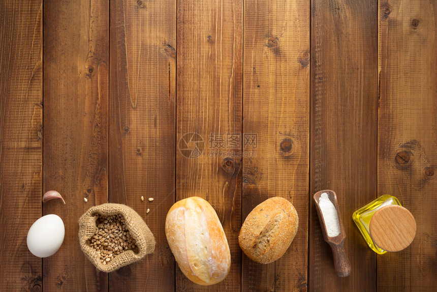 木制背景表顶视图上的面包材料图片