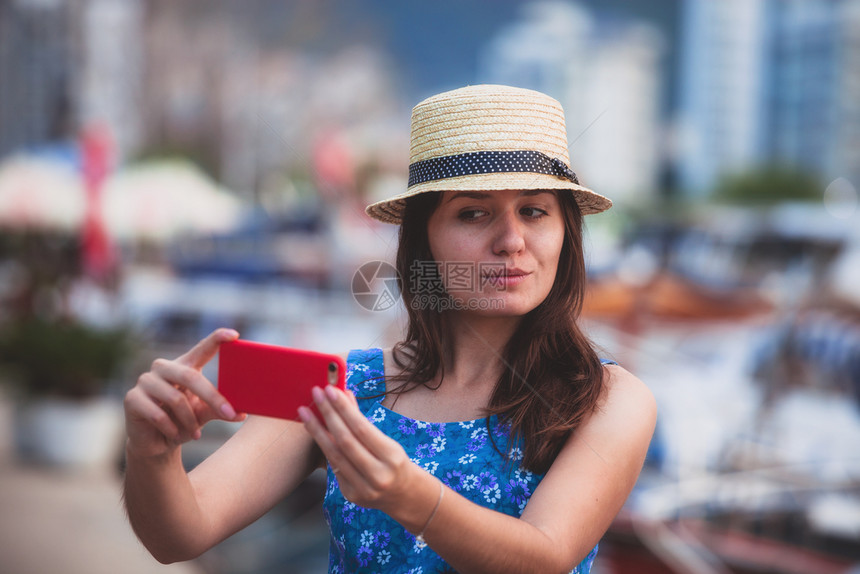 欧洲旅行自拍可爱的快乐笑旅游女孩在著名的欧洲地中海目暑假用智能手机拍摄自画像欧洲旅行自拍可爱的快乐笑旅游女孩在Sel拍摄自画像图片