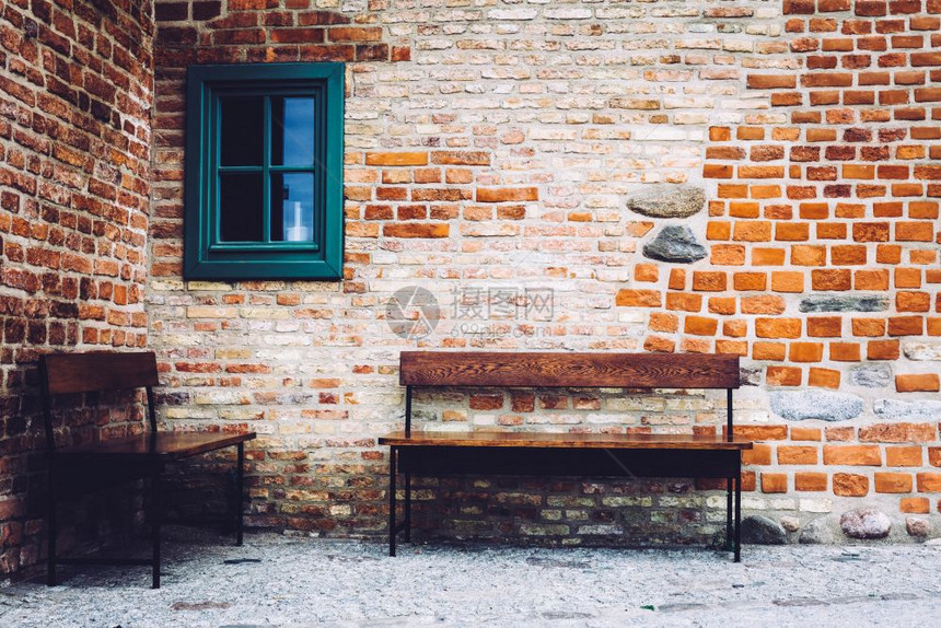波兰格丹斯克老城两张长椅站在旧楼前有绿窗图片