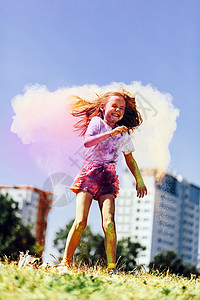 快乐的小女孩在公园里玩多彩的胡利粉混乱的欢乐快小女孩玩多彩胡利粉图片
