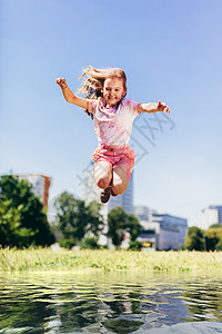 女孩跳过大水坑在外面玩耍图片