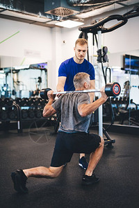 高级男子与个人教练一起锻炼退休后运动生活方式图片
