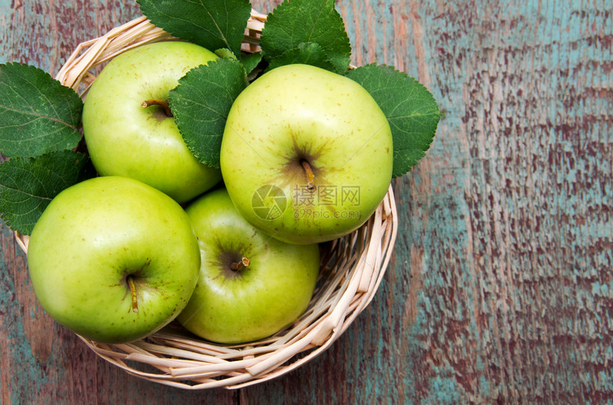 绿苹果放在木制桌上图片