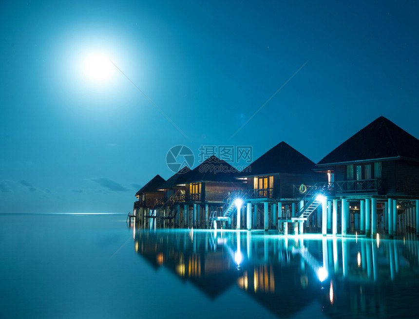 马尔代夫岛日落豪华自来水别墅度假胜地和木码头美丽的天空和云彩以及暑假旅行的海滩背景概念图片