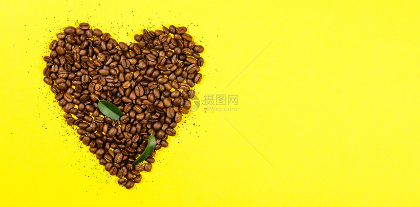 黄底的心形咖啡豆的平躺着顶端视野图片