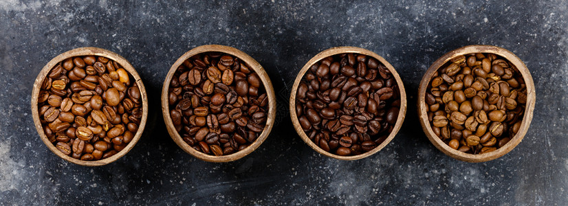 4种不同的咖啡豆平铺有4种不同的咖啡豆放在深大理石底复制空间上背景图片