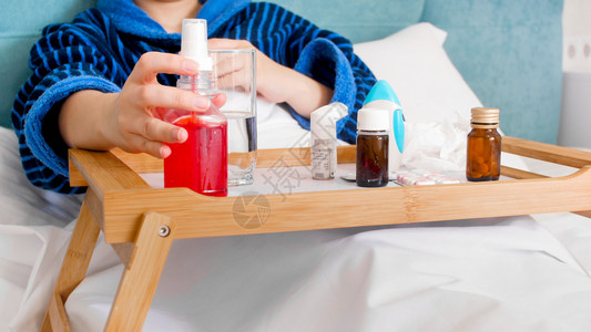 生病的年轻妇女躺在床上用大量的药品和喷雾剂图片