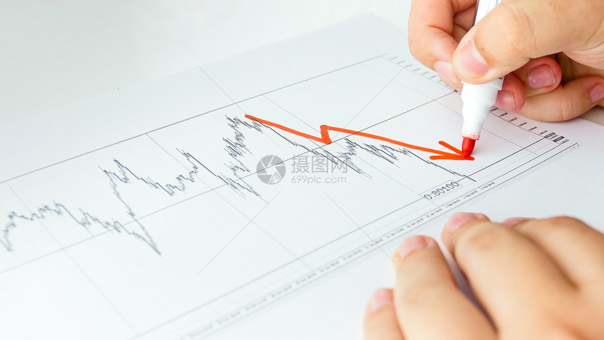 商业分析员在股票销售图上绘制下降的表商业分析员在股票销售图上绘制下降的表图片
