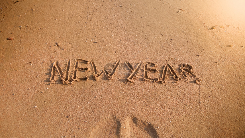新年在海滨的湿沙上写下新年图片冬季假日圣诞节和旅游的概念新年在海滨的湿沙上写新年图片图片