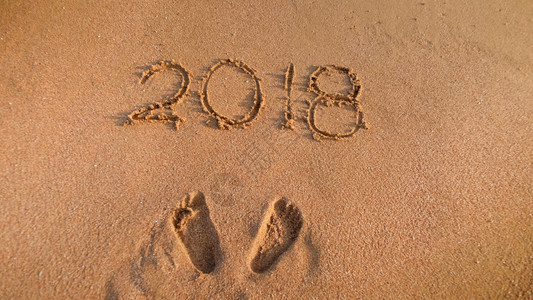 数字潮素材在沙滩上写下2018年数字的近距离图像冬季假日庆祝和旅行的概念2018年数字的近距离照片在沙滩上写冬季假日庆祝和旅行的概念背景