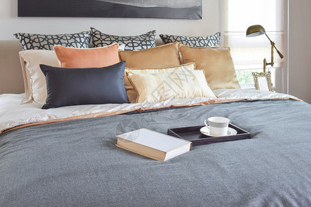 现代卧室内装饰的木板上茶杯和床白书装饰的茶杯图片