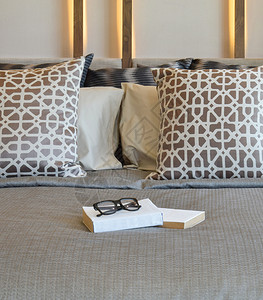时髦的卧室内设计棕色枕头和床上的书图片