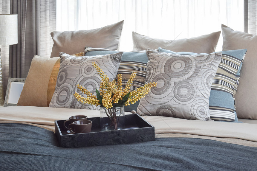 室内设计带有条纹枕头和床上装饰茶图片