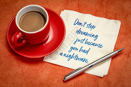 梦想从未停止不要停止做梦只是因为你做了个噩梦手写在餐巾纸上加一杯咖啡背景
