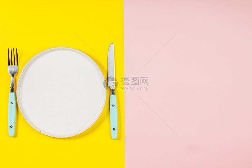 白板刀和叉的平白刀和叉放在两种彩色糊面背景上图片