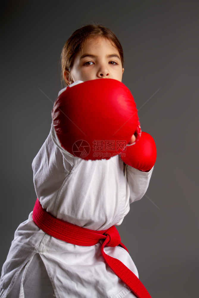 穿红腰带运动手套的小女孩和白服用右手打图片