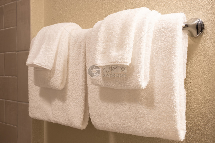 干净的白毛巾放在一个准备使用的衣架上图片