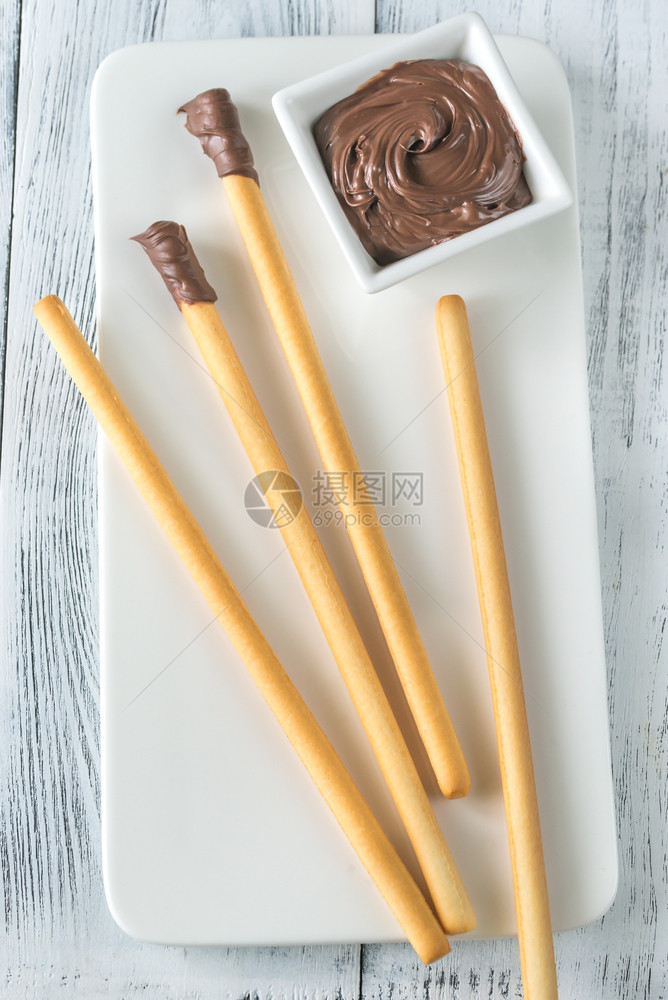 俯视图沾巧克力奶油的面包棒图片