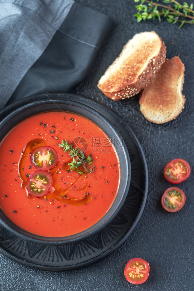 一碗辣番茄汤盛满橄榄油黑辣椒和樱桃西红柿图片