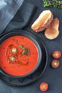 一碗辣番茄汤盛满橄榄油黑辣椒和樱桃西红柿背景图片