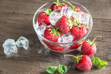 玻璃碗里有冰块的新鲜草莓图片