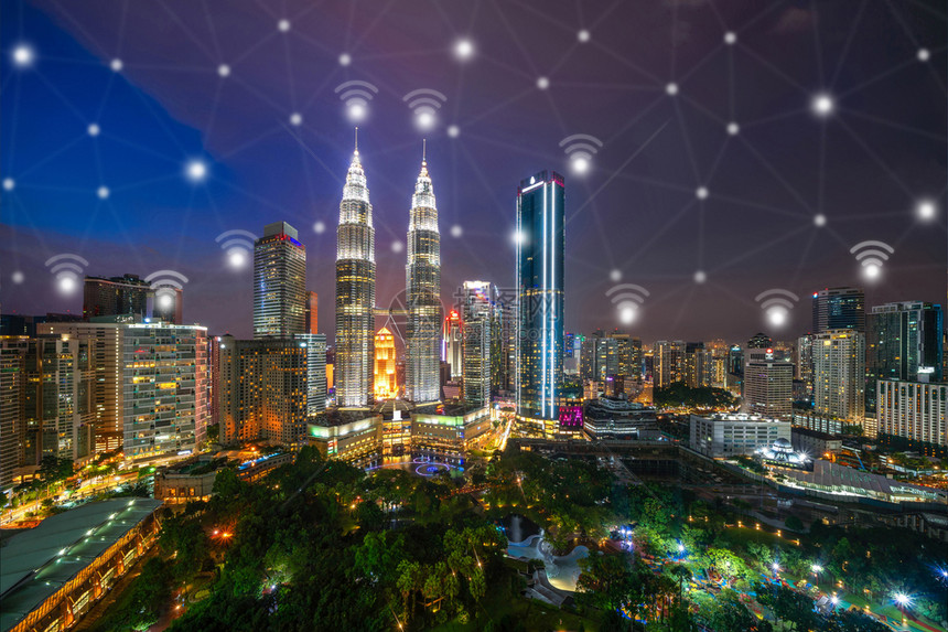 数字网络连接线和与马来西亚吉隆坡市下的Wifi图标智能城市金融区在技术概念方面的智能城市夜间的Skycraper和高楼大图片