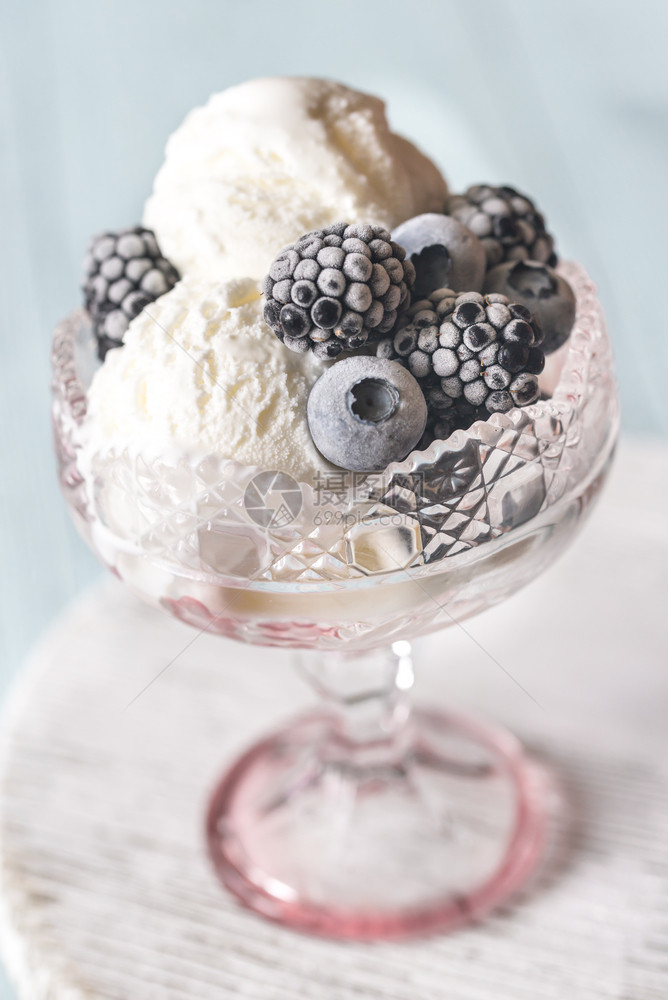 香草冰淇淋玻璃花瓶里有冻浆果图片