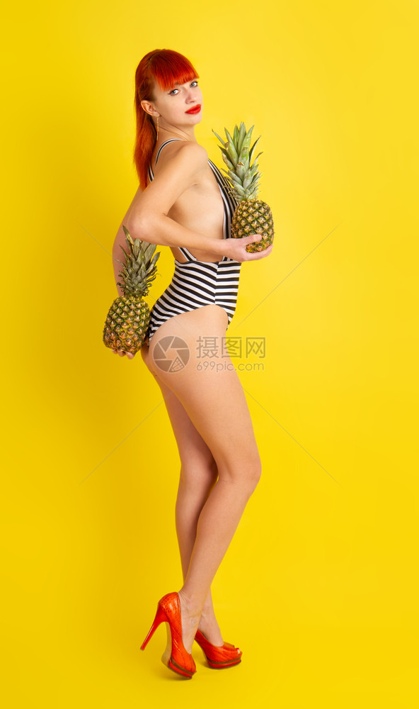 穿着紧闭的条纹泳衣手握菠萝的图片