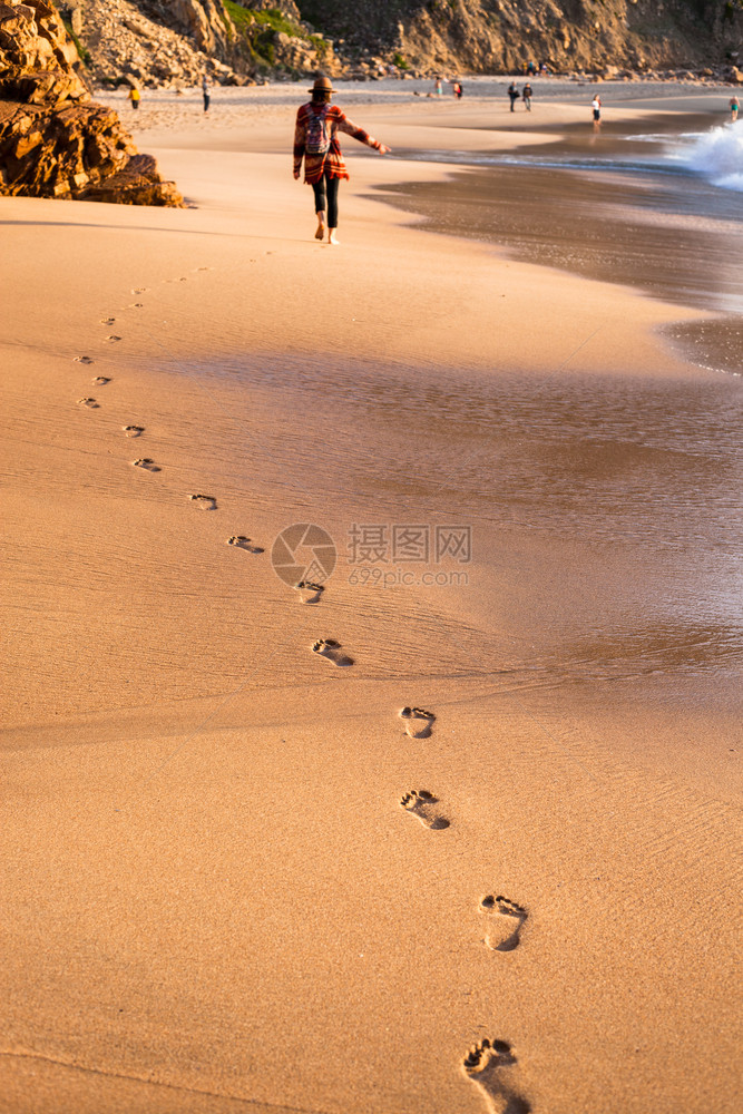 日落时热带海滩的浪和脚印图片