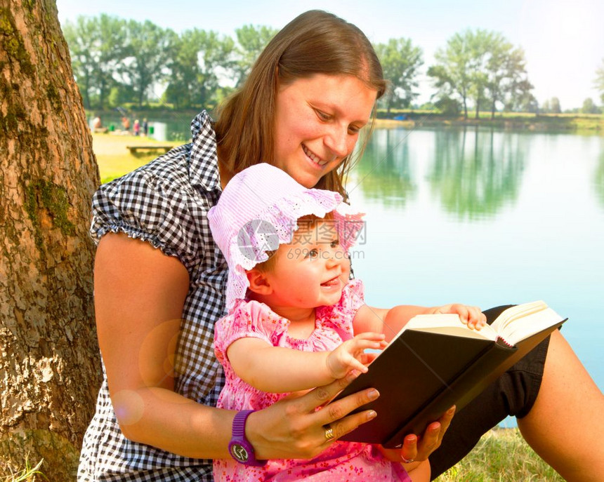 美丽的小女孩和母亲一起读书图片