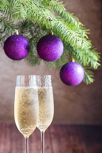 紫色长笛两杯香槟加圣诞树枝背景