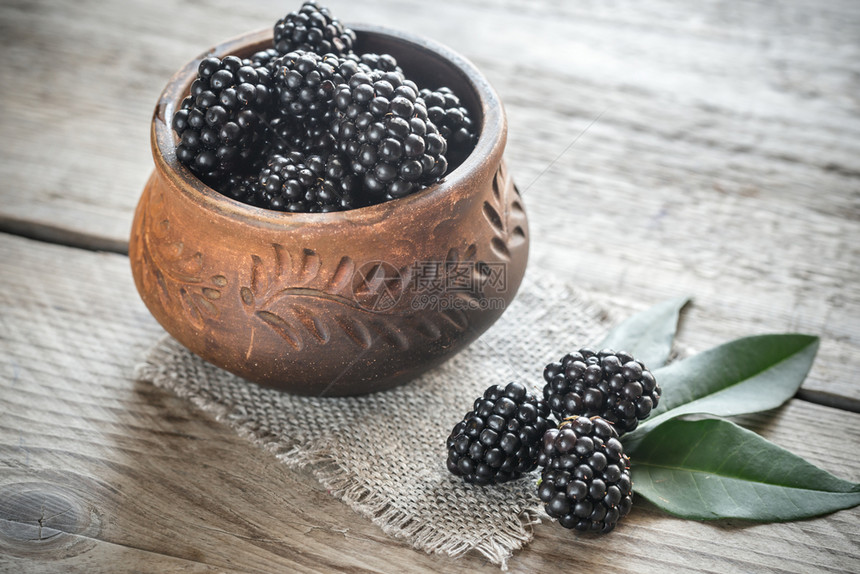 木制桌上的黑莓碗图片