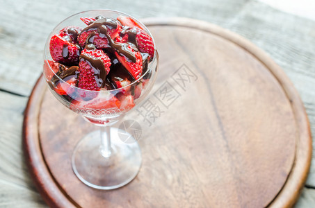 巧克力涂在玻璃杯下的新鲜草莓图片