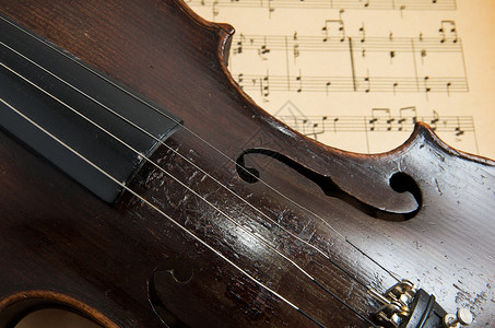 音乐概念和谱上的旧小提琴图片