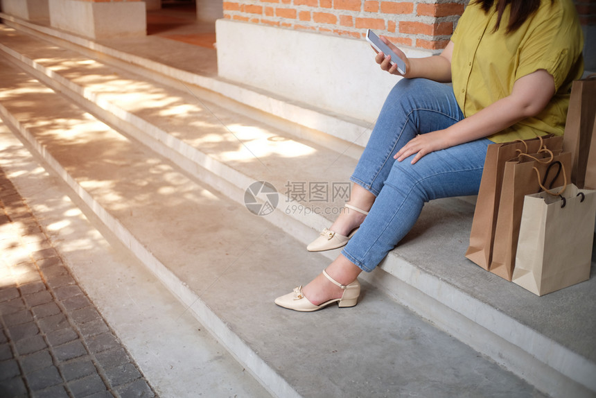 亚洲女孩持有销售袋的购物中心消费主义生活方式概念图片