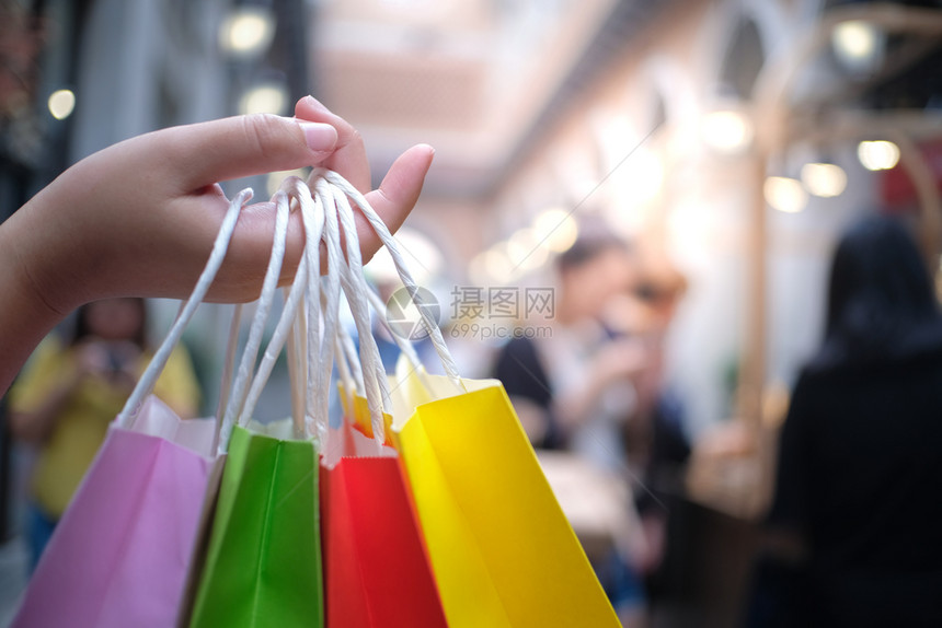 亚洲女孩持有销售袋的购物中心消费主义生活方式概念图片