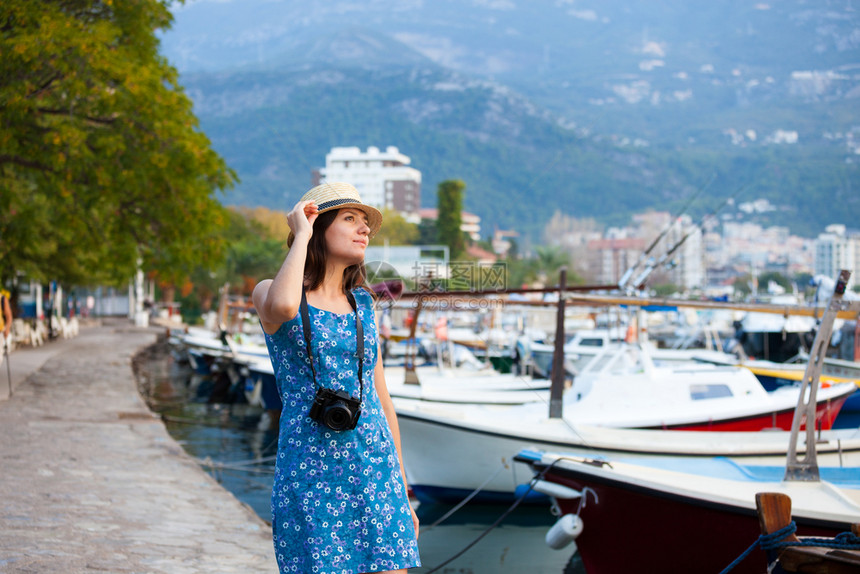 年轻有吸引力的快乐旅行女孩在旧地中海城市滨带相机行走夏季度假旅行概念年轻有吸引力的快乐旅行女孩带着相机走图片