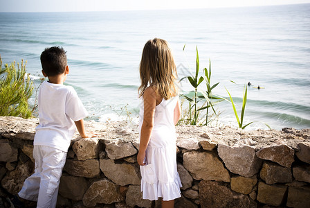 两个身着白色衣服的孩子看着大海图片