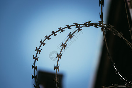 监狱或军事基地有刺铁丝网的近距离视背景