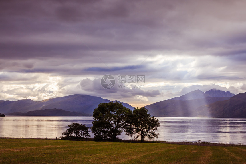 苏格兰美丽的神秘景观湖风天空草原树木和太阳光覆盖多云的天空树木和太阳光图片