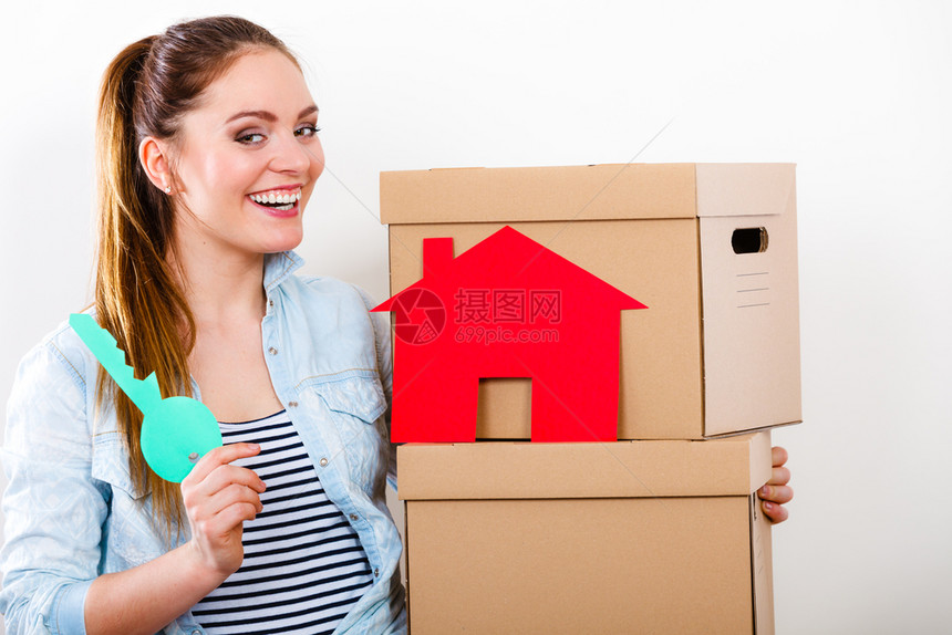 快乐的女子搬进装有红色纸房和钥匙的箱中年轻女子在新公寓家安排内置和拆行李妇女带着盒子和纸房钥匙搬进来图片