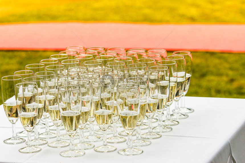 白桌上有很多香槟杯子婚礼派对上外门拍摄图片