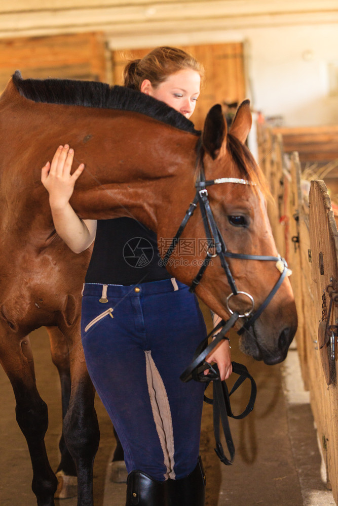 骑马的年轻女孩抚摸和拥抱着稳定的棕色马骑年轻女孩抚摸和拥抱着棕色马图片